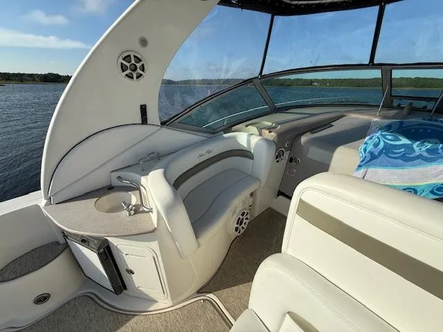 Slide: The Image of 2007 Sea Ray 320 Sundancer interior with seating and helm, overlooking serene water. - 7