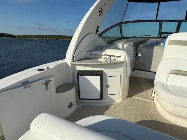 Slide: The Image of 2007 Sea Ray 320 Sundancer interior with seating and kitchenette, overlooking calm waters. - 8