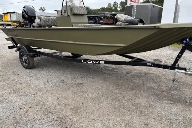 Slide: The Image of 2026 Lowe Roughneck RX1860 CC boat on trailer, parked outdoors. - 3