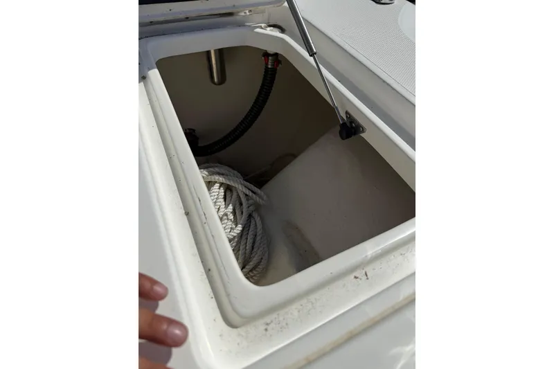 Slide: The Image of Open storage compartment on 2023 World Cat 255 DC boat with coiled rope inside. - 15