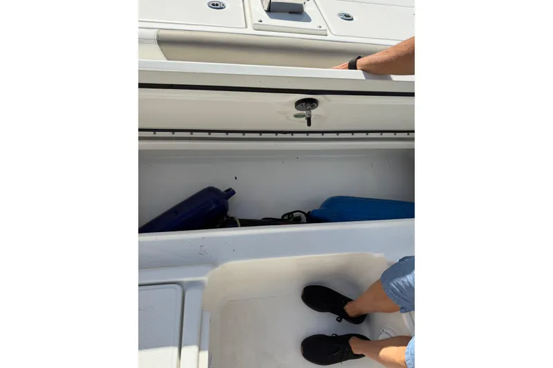 Slide: The Image of Open storage compartment on 2023 World Cat 255 DC boat with visible equipment. - 16