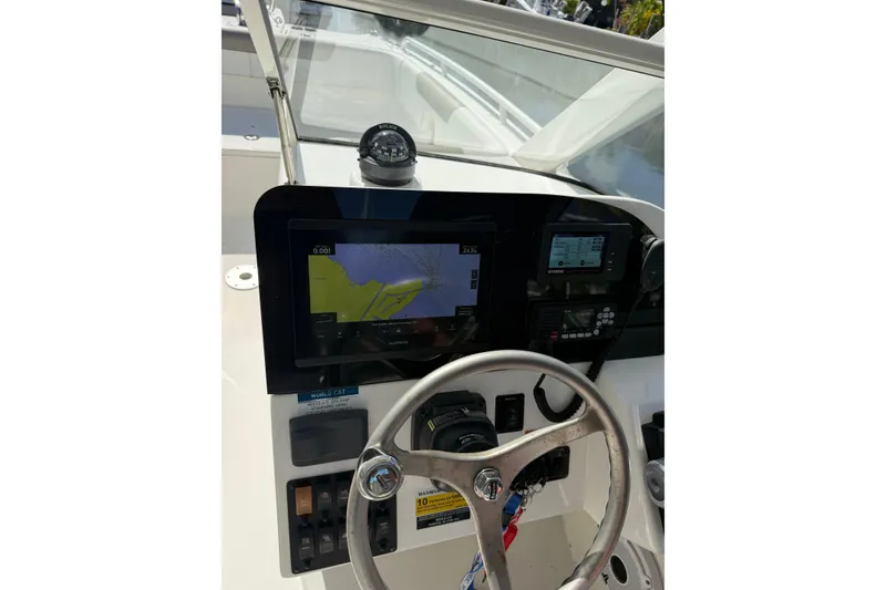 Slide: The Image of 2023 World Cat 255 DC boat dashboard with navigation screen and compass. - 8