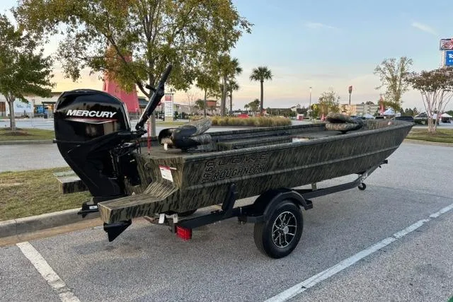 The Image of 2026 Lowe Roughneck 1760 Deluxe Tiller boat on trailer in parking lot. - 1