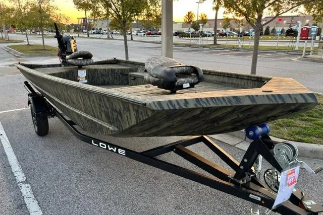 Slide: The Image of 2026 Lowe Roughneck 1760 Deluxe Tiller boat on trailer in parking lot. - 4