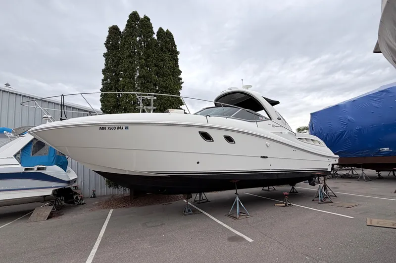 The Image of 2008 Sea Ray Sundancer 330 yacht on stands in a marina parking lot. - 0