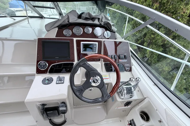 Slide: The Image of Helm of 2008 Sea Ray Sundancer 330 with steering wheel and navigation controls. - 12