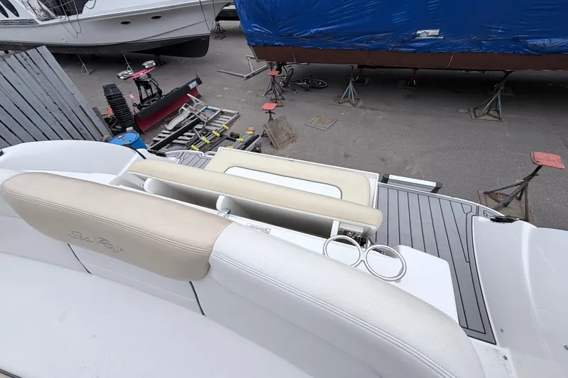 Slide: The Image of 2008 Sea Ray Sundancer 330 boat interior with seating and cup holders, docked in a marina. - 2