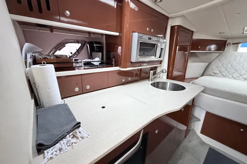 Slide: The Image of Interior of 2008 Sea Ray Sundancer 330 yacht featuring a modern kitchenette and cozy seating area. - 22