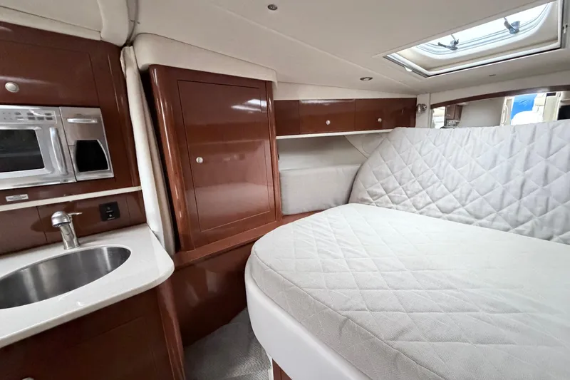 Slide: The Image of 2008 Sea Ray Sundancer 330 cabin interior with bed, sink, and microwave. - 24