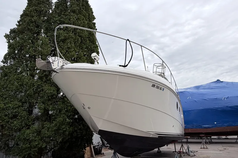 Slide: The Image of 2008 Sea Ray Sundancer 330 yacht on dry dock, with trees and a covered boat nearby. - 28