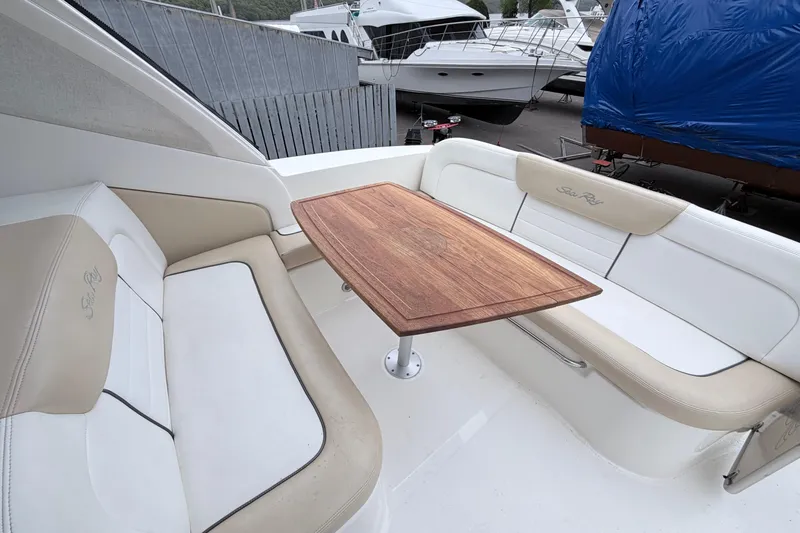 Slide: The Image of 2008 Sea Ray Sundancer 330 boat interior with cushioned seating and wooden table. - 3