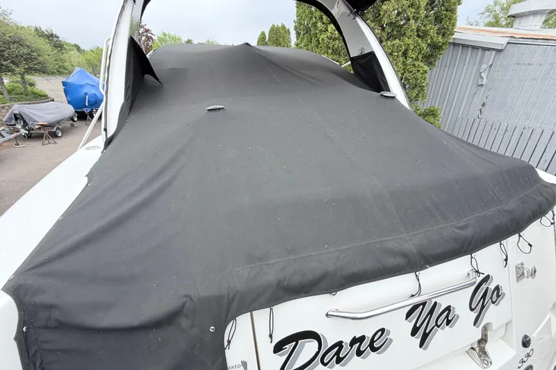 Slide: The Image of 2008 Sea Ray Sundancer 330 boat covered with a black tarp, docked outdoors. - 31