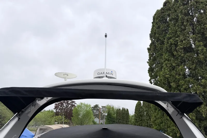 Slide: The Image of 2008 Sea Ray Sundancer 330 with Garmin radar, surrounded by trees under cloudy sky. - 44