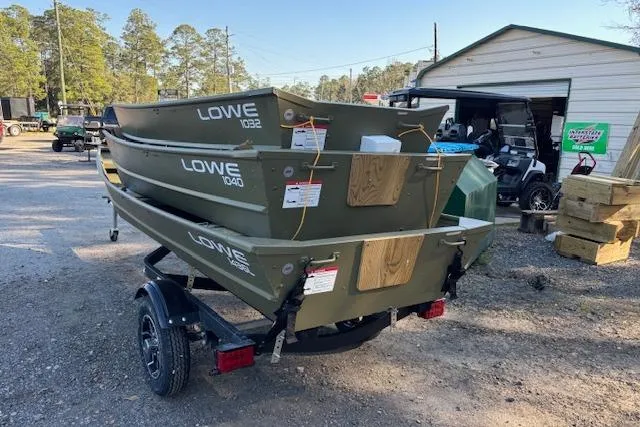 The Image of 2026 Lowe L1032 Jon boats stacked on a trailer in an outdoor setting. - 1