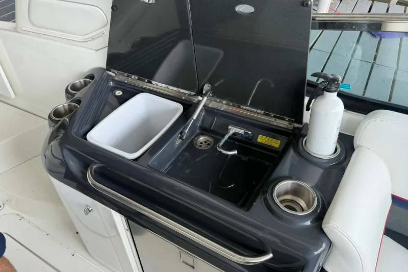 Slide: The Image of 2018 Formula 310 Sun Sport boat sink area with cup holders and fire extinguisher. - 13