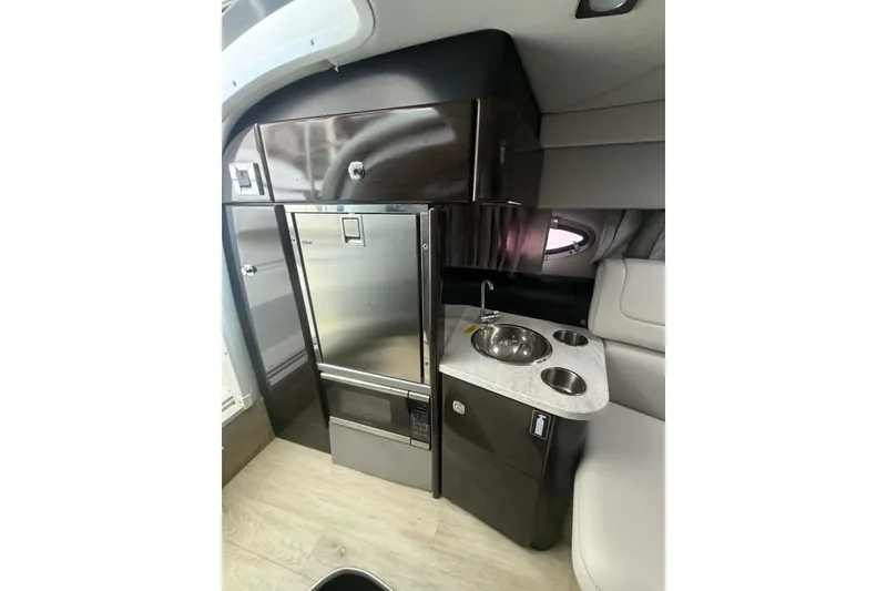 Slide: The Image of 2018 Formula 310 Sun Sport interior with kitchenette, stainless steel fridge, and modern design. - 16