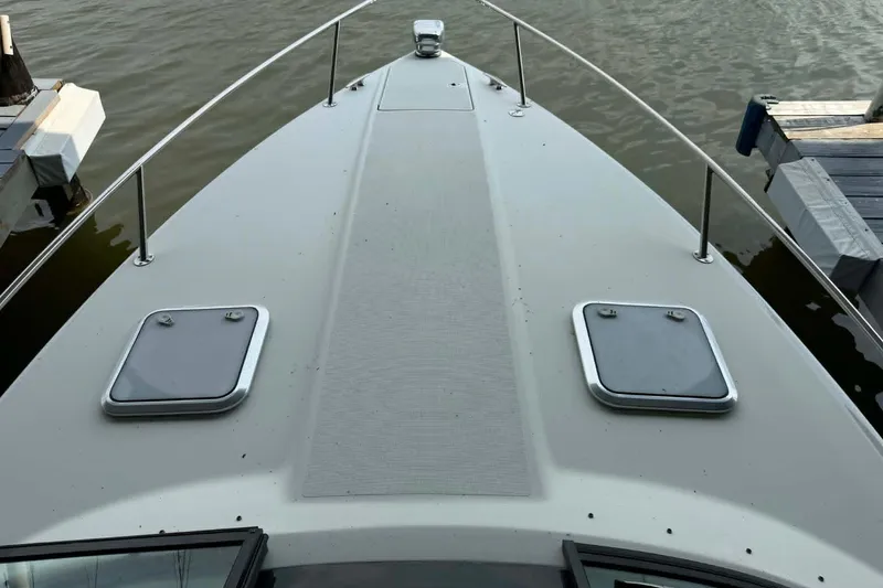 Slide: The Image of 2018 Formula 310 Sun Sport boat deck with hatches, docked on calm water. - 5
