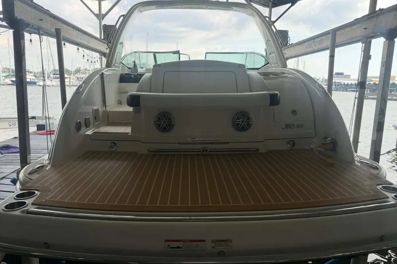 Slide: The Image of 2018 Formula 310 Sun Sport boat docked, showcasing spacious rear deck and sleek design. - 6