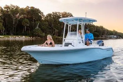 The Image of 2026 Tidewater 210 CC Adventure boat cruising on a serene lake at sunset. - 1