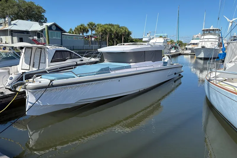 Slide: The Image of 2024 Axopar 37 XC Cross Cabin docked in a marina under clear blue skies. - 3