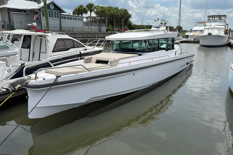Slide: The Image of 2024 Axopar 37 XC Cross Cabin boat docked in a marina, showcasing sleek design. - 4