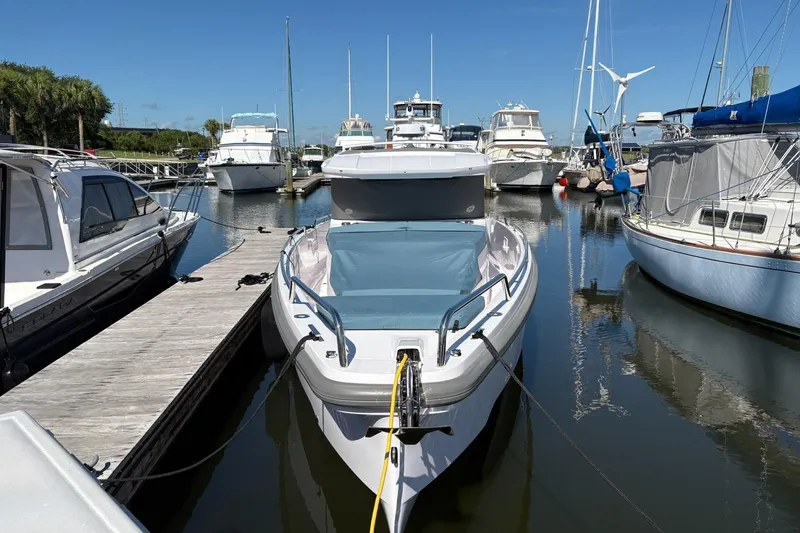 Slide: The Image of 2024 Axopar 37 XC Cross Cabin docked in a marina, surrounded by other boats. - 5