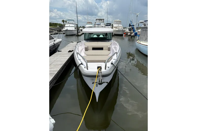 Slide: The Image of 2024 Axopar 37 XC Cross Cabin docked at marina, front view. - 6