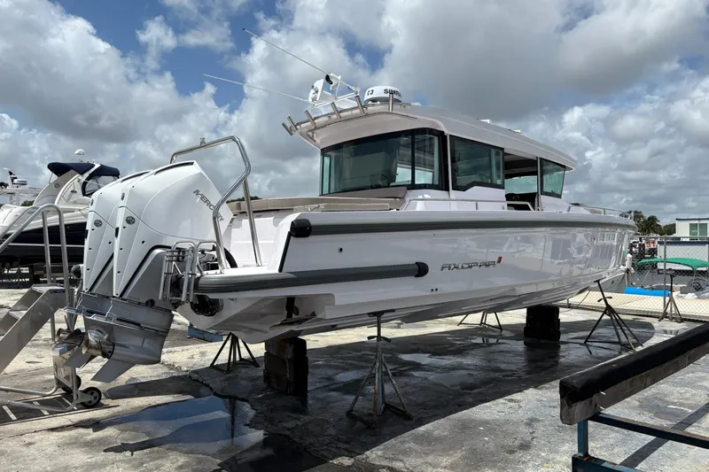 Slide: The Image of 2024 Axopar 37 XC Cross Cabin boat on stands, showcasing sleek design and powerful engine. - 7