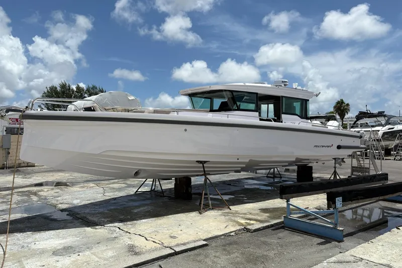 Slide: The Image of 2024 Axopar 37 XC Cross Cabin boat on dry dock under a bright blue sky. - 8
