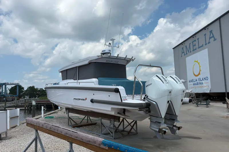 Slide: The Image of 2024 Axopar 37 XC Cross Cabin boat at Amelia Island Marina under cloudy sky. - 8