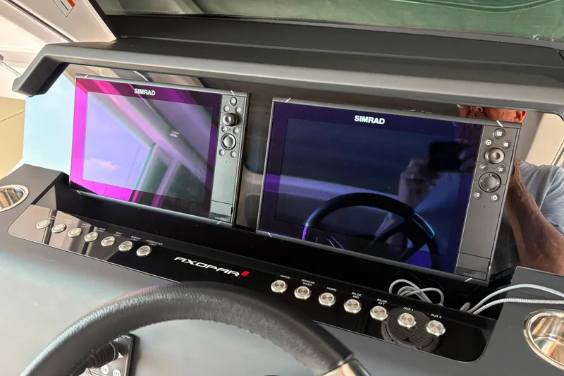 Slide: The Image of 2024 Axopar 37 XC Cross Cabin dashboard with dual Simrad displays and control panel. - 11