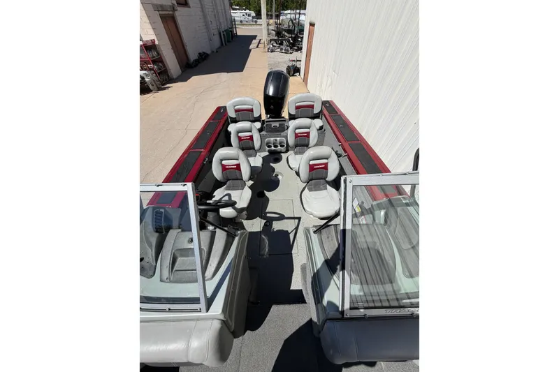 Slide: The Image of 2016 Bass Tracker Tournament V-18 boat with multiple seats, parked outdoors. - 15