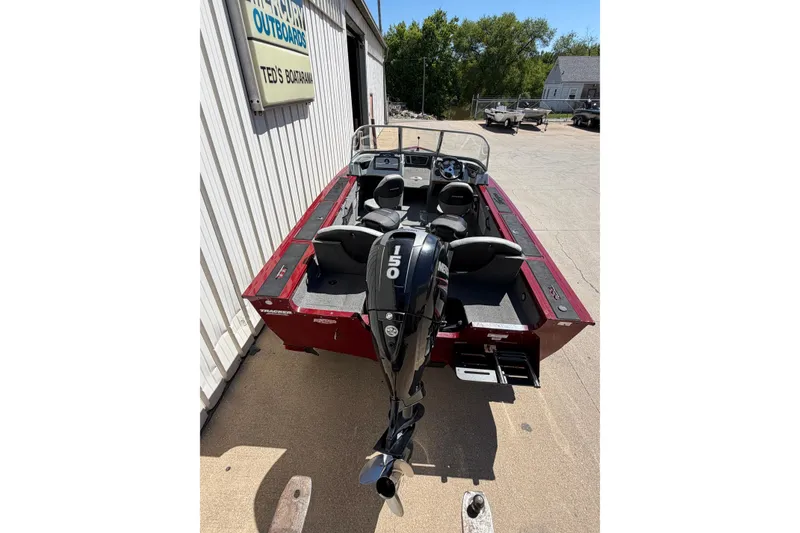 Slide: The Image of 2016 Bass Tracker Tournament V-18 boat with Mercury outboard motor, parked outside a dealership. - 18