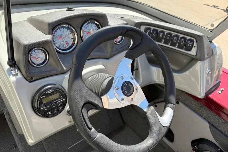 Slide: The Image of Dashboard of a 2016 Bass Tracker Tournament V-18 boat with steering wheel and gauges. - 24
