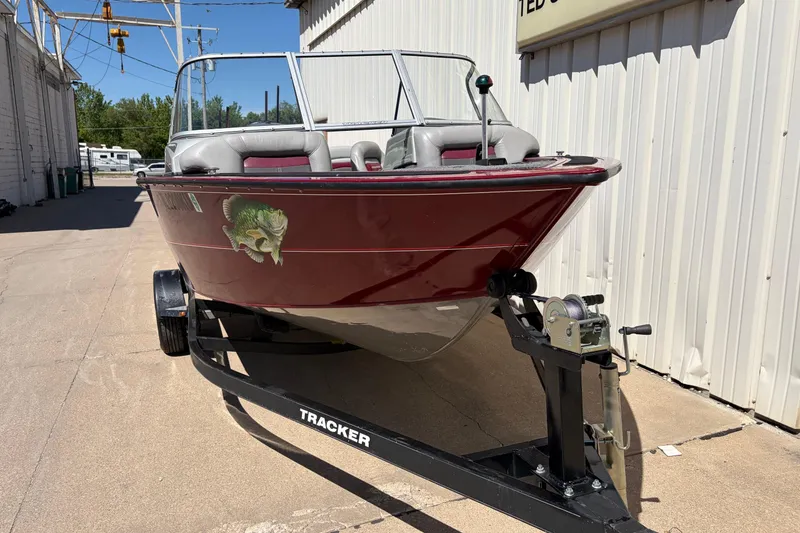Slide: The Image of 2016 Bass Tracker Tournament V-18 boat on trailer, parked outdoors. - 4