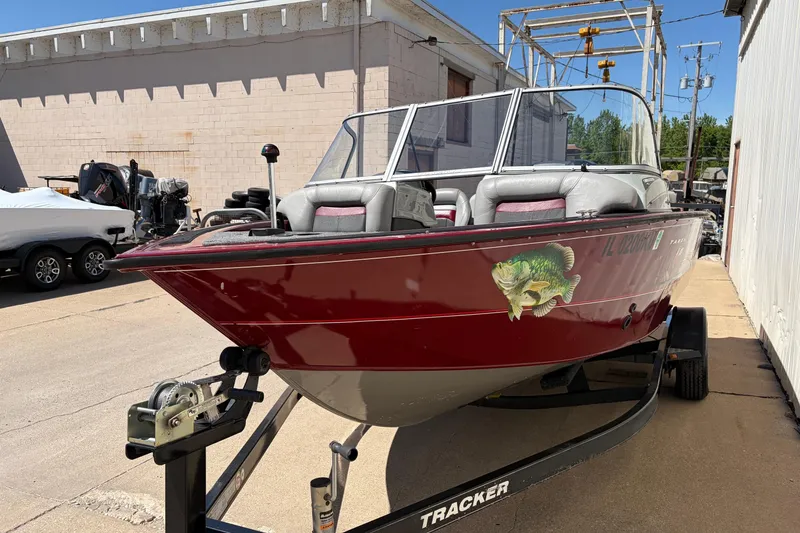 Slide: The Image of 2016 Bass Tracker Tournament V-18 boat on trailer, red exterior, parked outdoors. - 5