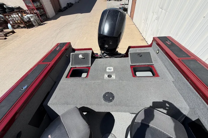 Slide: The Image of 2016 Bass Tracker Tournament V-18 boat interior with motor, storage compartments, and seating. - 6