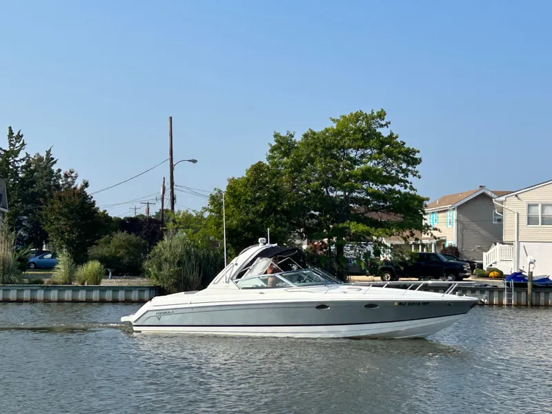 Slide: The Image of 2005 Formula 330 Sun Sport boat on calm water near houses. - 1