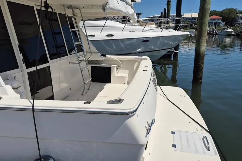 Slide: The Image of 2008 Meridian 490 Pilothouse yacht docked at marina, featuring spacious deck and ladder. - 28