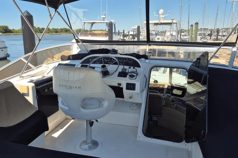 Slide: The Image of 2008 Meridian 490 Pilothouse interior with helm, steering wheel, and navigation equipment. - 7