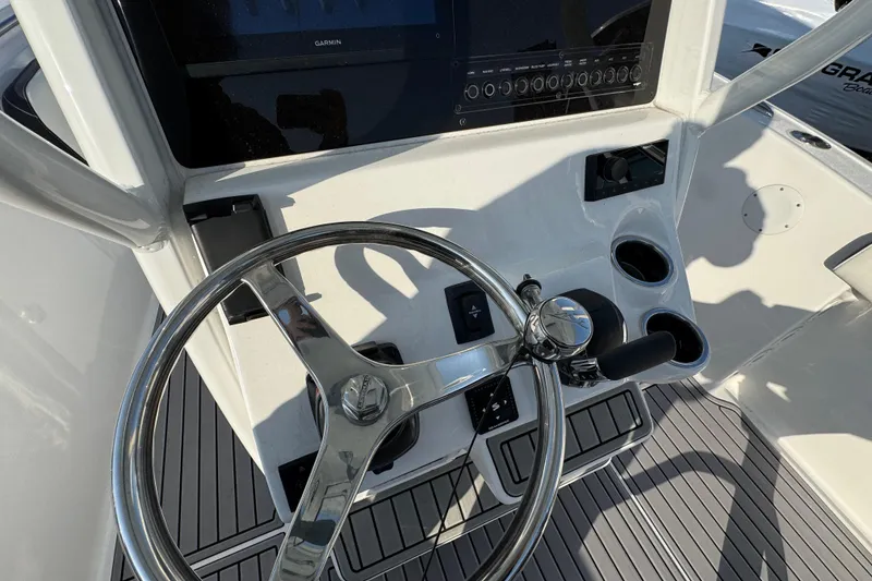 Slide: The Image of Steering console of 2026 Tidewater 232 SS boat with modern controls and cup holders. - 10