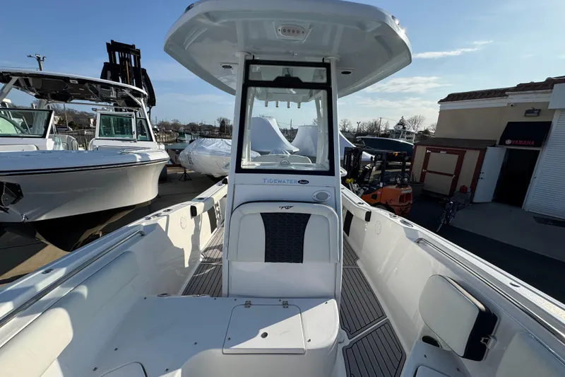 Slide: The Image of 2026 Tidewater 232 SS boat with sleek design, docked outdoors under clear skies. - 19
