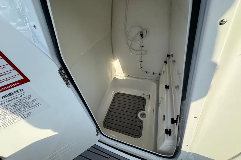 Slide: The Image of Interior view of 2026 Tidewater 232 SS boat compartment with drainage and storage features. - 22