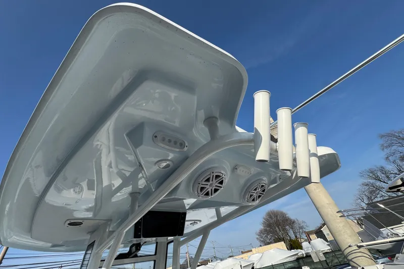 Slide: The Image of 2026 Tidewater 232 SS boat's underside view with rod holders and speakers against blue sky. - 6