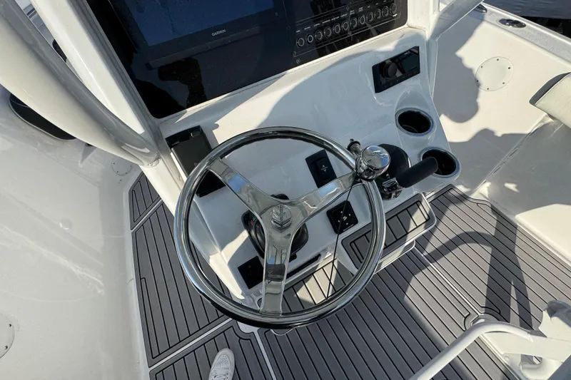 Slide: The Image of Steering console of 2026 Tidewater 232 SS boat with modern controls and cup holders. - 8