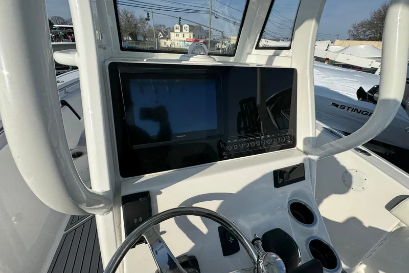 Slide: The Image of 2026 Tidewater 232 SS boat dashboard with Garmin display and steering wheel. - 9