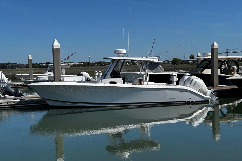 The Image of 2024 Pursuit S 288 Sport boat docked in a marina under clear blue skies. - 0