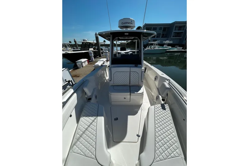 Slide: The Image of 2024 Pursuit S 288 Sport boat interior with quilted seating, docked at marina. - 1