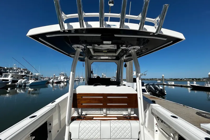 Slide: The Image of 2024 Pursuit S 288 Sport boat docked at marina, showcasing sleek design and luxury seating. - 10