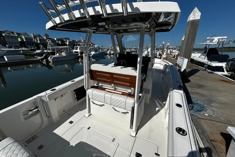 Slide: The Image of 2024 Pursuit S 288 Sport boat docked at marina, showcasing sleek design and spacious deck. - 11